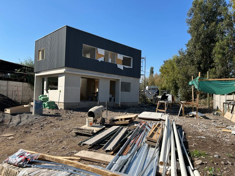 Casa de dos pisos con revestimiento gris y blanco y ventanas en instalación